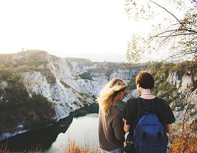 two women standing on high ground surrounded by mountain during daytime thumbnail