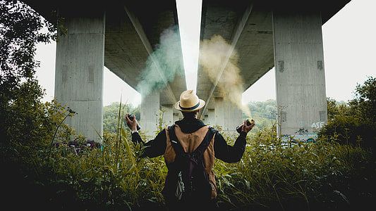 man holding spray under bridge during daytime thumbnail