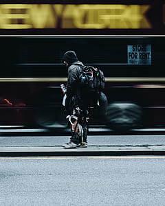 man carrying backpack standing on asphalt road thumbnail