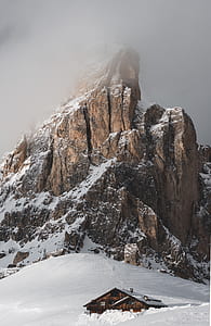 house near snow-covered mountain thumbnail