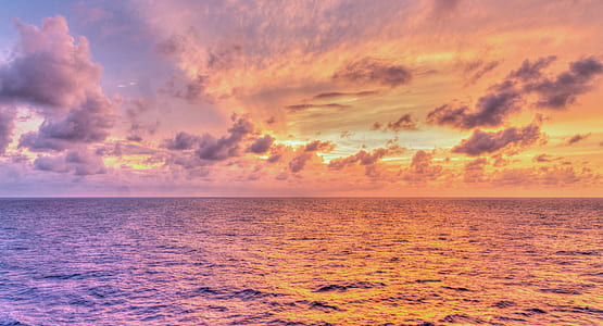 body of water under orange sky thumbnail