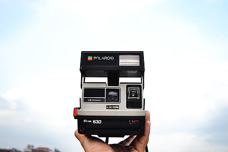 person holding gray and black Polaroid camera thumbnail