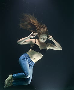 woman wearing black brassiere and jeans underwater thumbnail