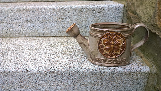 brown watering can on staircase thumbnail