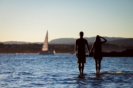 man and woman standing on body of water thumbnail