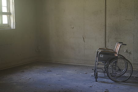 grey and brown wheel chair placed near corner of room thumbnail