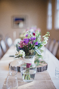 selective focus photography of purple, white, and pink flower centerpiece on clear glass flower vase thumbnail