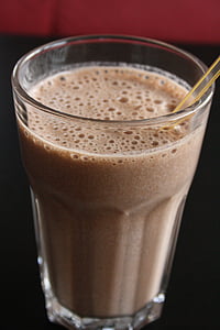 clear drinking glass filled with brown beverage with straw thumbnail