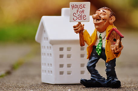 ceramic man holding house for sale figurine thumbnail