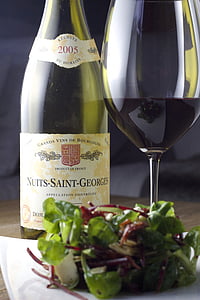 Nuits-Saint-Georges bottle beside plate with wine glass with leafy vegetables thumbnail