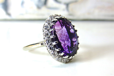 silver-colored ring with purple gemstone on white table thumbnail
