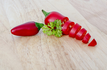 two red chili peppers on wooden surface thumbnail