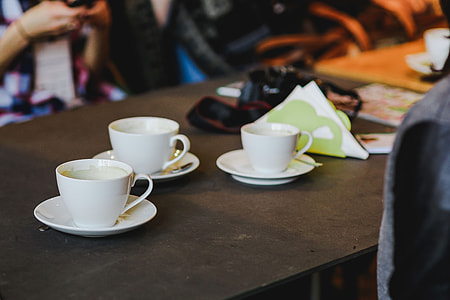 Laptop, a smartphone, magazines and cups of coffee on a table thumbnail