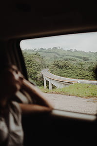 woman leaning and looking out the vehicle window thumbnail