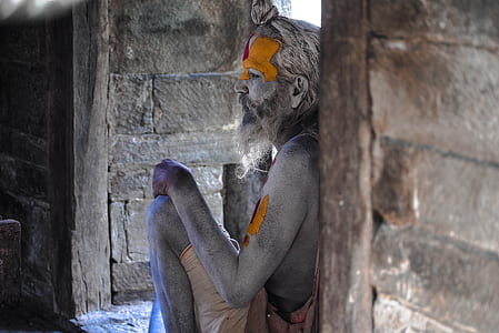 man sitting leaning on brown wooden wall thumbnail
