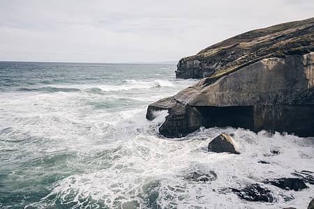 landscape photography of rock formations near shore thumbnail