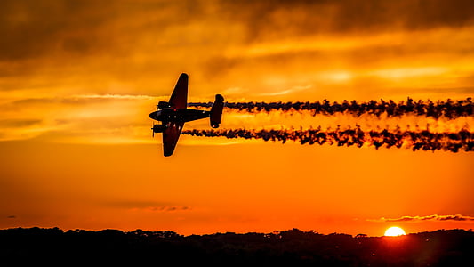 silhouette of plane under orange sky thumbnail