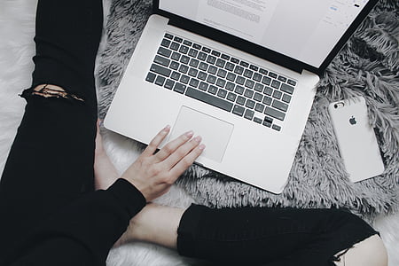 person using MacBook Pro on gray fleece textile thumbnail