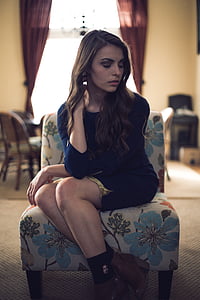 woman in blue mini dress sitting on floral chair thumbnail