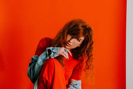 woman wearing red short-sleeved top and blue jacket thumbnail
