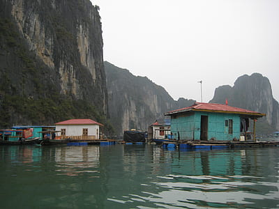 houses surrounded by body of water near mountains thumbnail