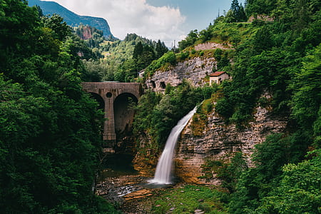 waterfall beside concrete bridge thumbnail