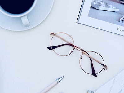 Brown Framed Eyeglasses Near Cup of Coffee on White Surface thumbnail