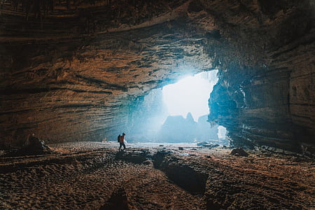 man walking inside the cave during daytime thumbnail