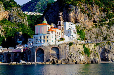 white and brown concrete building beside body of water during daytime thumbnail