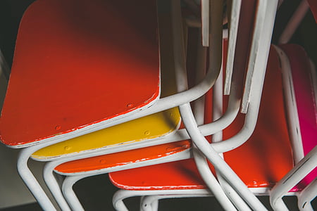 orange, white, and yellow metal chairs inside room thumbnail