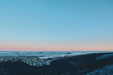 brown rocks beside seashore thumbnail