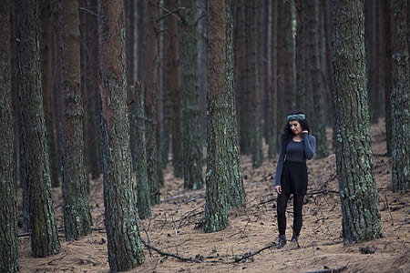 woman standing beside trees thumbnail