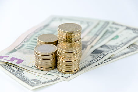 close-up photo of round gold-colored coins and US dollar banknotes thumbnail