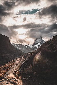 brown rocky mountain under white and blue cloudy sky thumbnail