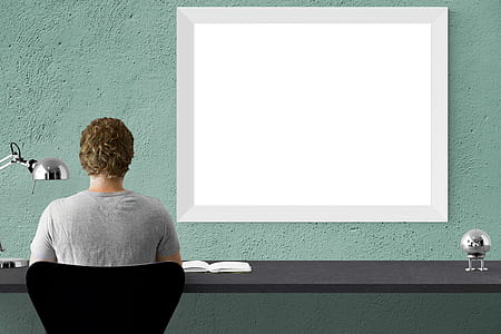 person sitting on black chair in front of desk thumbnail