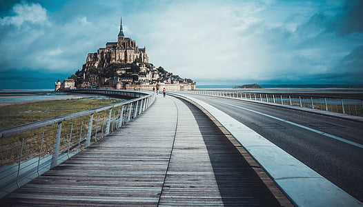 person walking on road towards island with buildings thumbnail