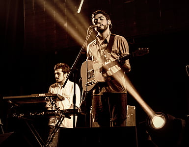 person holding guitar while singing on stage thumbnail