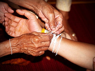 person holding white textile tied on person's arm thumbnail
