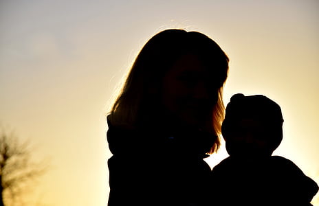 silhouette of woman with baby during sunset thumbnail