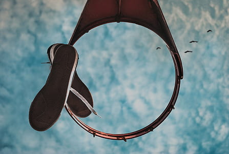 low angle photography of basketball ring with hanged sneakers thumbnail