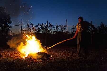 man holding stick burning wood thumbnail