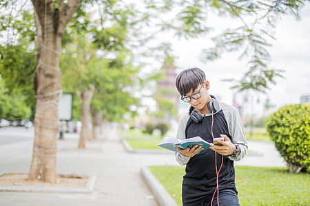 boy wearing headphones and reading book thumbnail