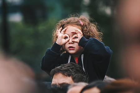 girl using hands as binocular sitting on top man thumbnail