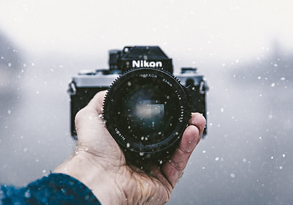 person holding black Nikon DSLR camera thumbnail
