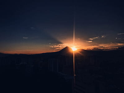 sun slightly covered by mountain thumbnail