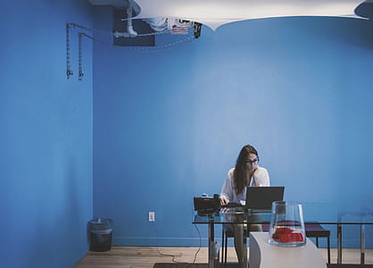 woman in white long-sleeved top sitting in front of desk thumbnail