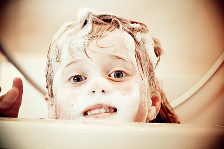 toddler covered with bubbles during daytime thumbnail