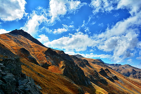 mountains under cloudy sky at daytime thumbnail