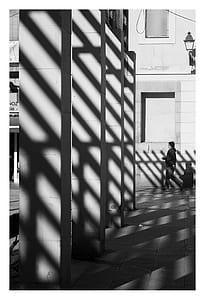 Grayscale Photography of Man Wearing Pullover Hoodie Near Gray Wall thumbnail