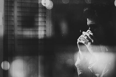 grayscale photo of man near window thumbnail